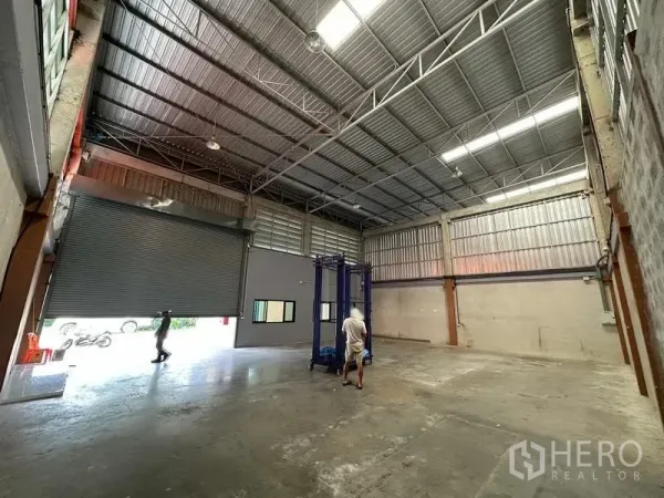 货栈 出租在Khlong Luang, Pathum Thani - 仓库内部高挑空间，宽幅卷闸门与抛光混凝土地面。