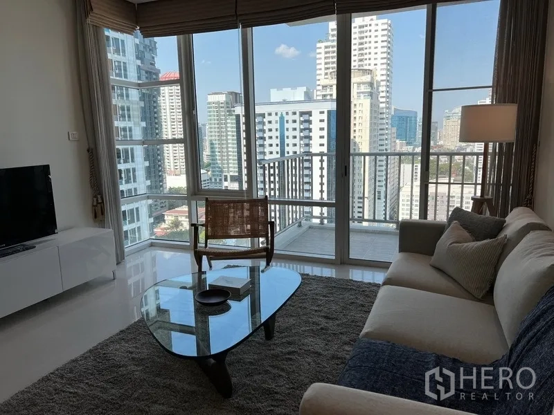 คอนโด ให้เช่าในWatthana, Bangkok - มุมรับแขกติดผนังกระจกมองเห็นวิวเมือง พร้อมทางออกสู่ระเบียงเล็ก