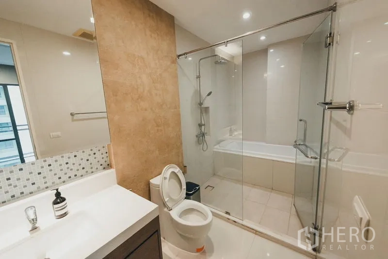 คอนโด ให้เช่าในKhlong Toei, Bangkok - ห้องน้ำหลัก กระจกกั้นอาบน้ำพร้อมอ่างอาบน้ำในตัว เคาน์เตอร์อ่าง และโถสุขภัณฑ์