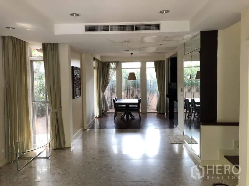 บ้าน ขายในWang Thonglang, Bangkok - พื้นที่นั่งเล่นและรับประทานอาหารกว้าง ผนังกระจกสูง ฝ้าเพดานไฟดาวน์ไลท์ และผนังกระจกเงา.