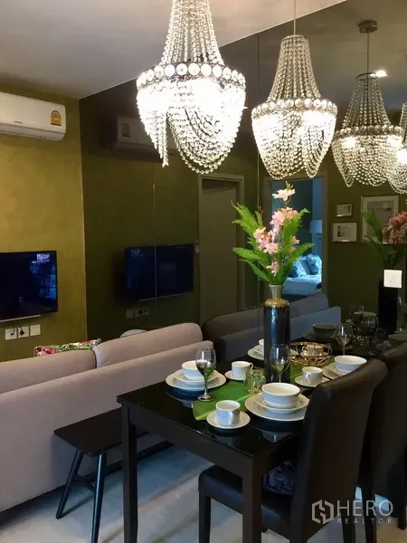 คอนโด ให้เช่าในKhlong Toei, Bangkok - โต๊ะทานอาหารจัดเต็มสำหรับสี่ที่นั่ง ใต้โคมระย้าและผนังกระจกเงา