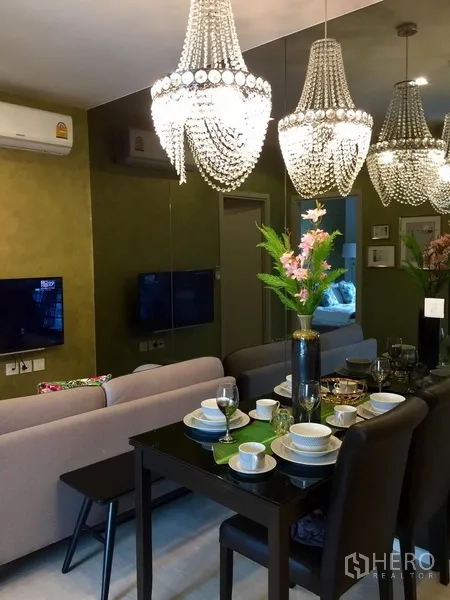 คอนโด ให้เช่าในKhlong Toei, Bangkok - โต๊ะทานอาหารจัดเต็มสำหรับสี่ที่นั่ง ใต้โคมระย้าและผนังกระจกเงา
