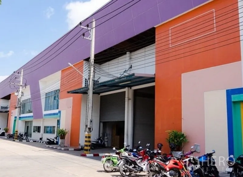 工厂 出租在Mueang Samut Sakhon, Samut Sakhon - 彩色外立面的工厂，配大卷帘门、雨棚装卸位和前方停车区，位于沙没沙空府