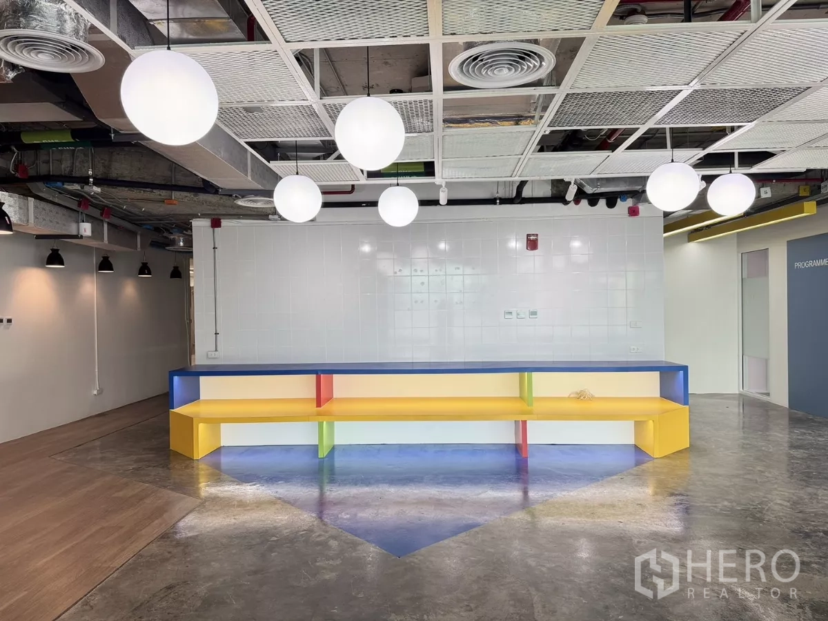 办公空间 出租在Din Daeng, Bangkok - 休闲区配彩色长凳与现代吊灯。