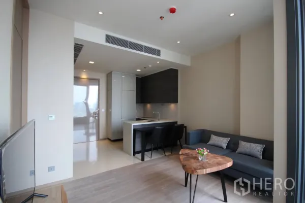 Condominium for rent in Watthana, Bangkok - Open-plan living area with modern kitchenette, island dining and recessed lighting.