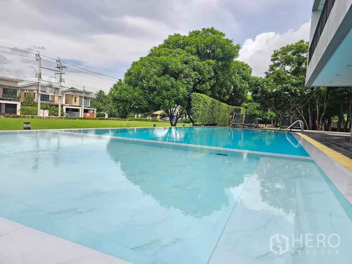 Detached House for rent or sale in Don Mueang, Bangkok - Communal swimming pool with landscaped gardens and modern clubhouse.