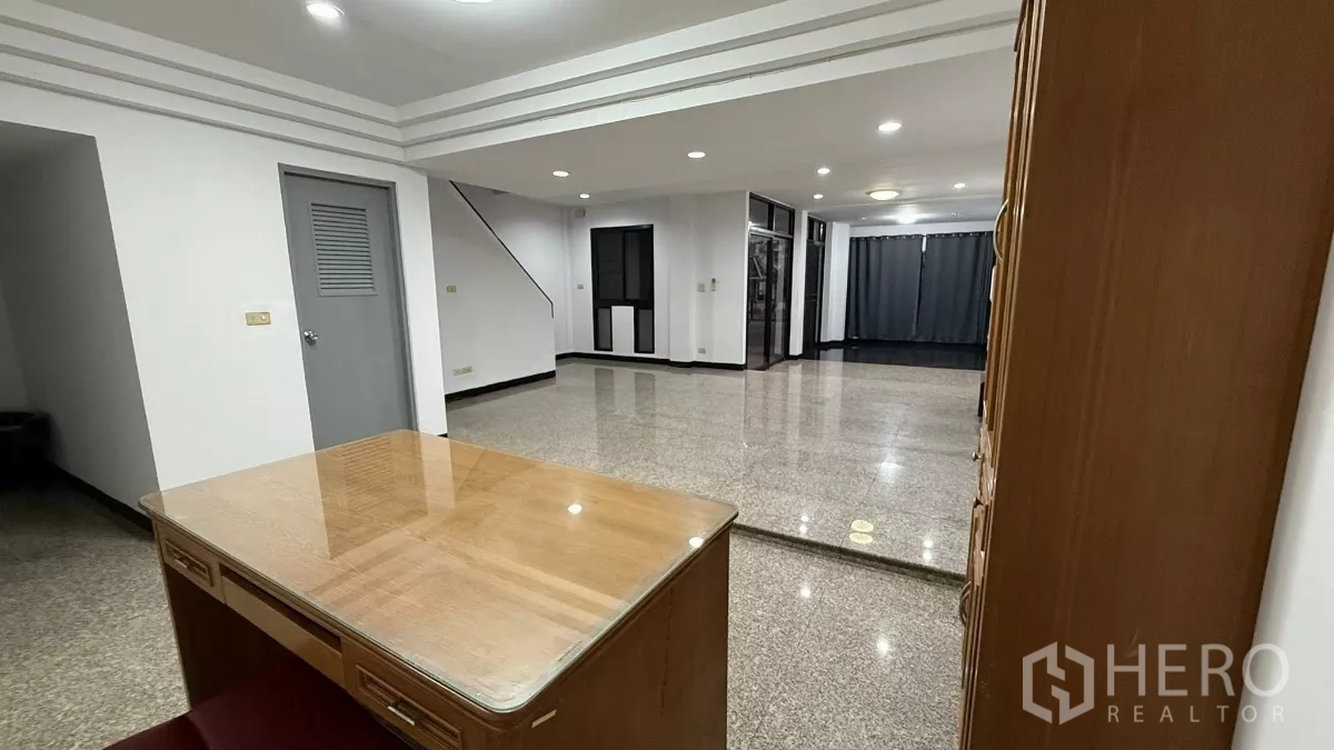 带办公室的家 出租在Bang Na, Bangkok - 一层开放式空间，抛光石材地面、筒灯照明、楼梯与玻璃隔断。