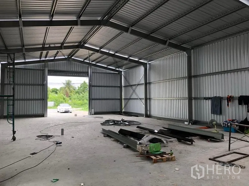 คลังสินค้า ให้เช่าในBang Yai, Nonthaburi - พื้นที่โกดังโล่ง มองออกไปยังประตูบานใหญ่ แสงธรรมชาติ รถจอดด้านนอก