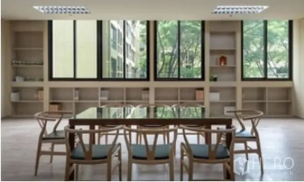 办公空间 出租在Chatuchak, Bangkok - 现代会议区，玻璃桌与木椅，内置书架，大窗外景观绿意盎然。