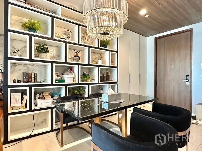 Condominium for rent in Pathum Wan, Bangkok - Dining area perspective showing display shelves and entry door.