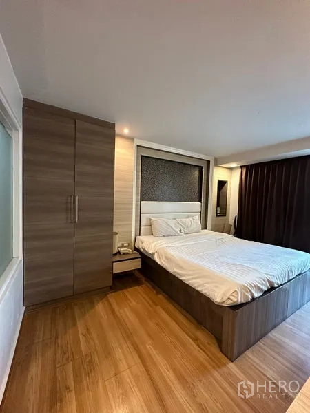 Apartment for rent in Khlong Toei, Bangkok - Bedroom with wood floors, built-in wardrobe and a queen bed.