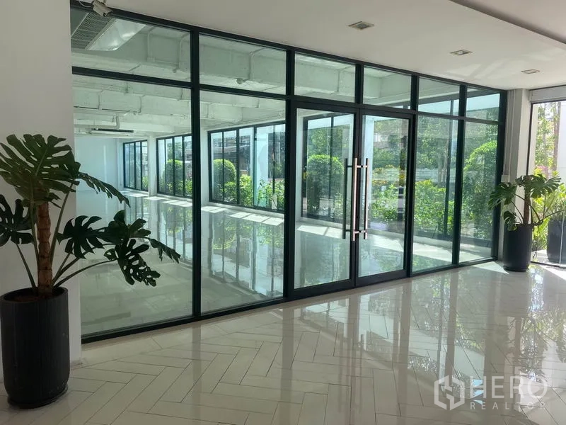 สำนักงาน ให้เช่าในKhlong Toei, Bangkok - โถงต้อนรับสว่าง ผนังกระจกเต็มบาน ประตูบานคู่ กระถางต้นไม้ พื้นกระเบื้องเงา