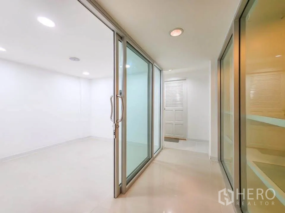 สำนักงาน ให้เช่าในKhlong Toei, Bangkok - ทางเดินกั้นด้วยผนังกระจก เปิดสู่ห้องประชุมหรือออฟฟิศโทนขาว.