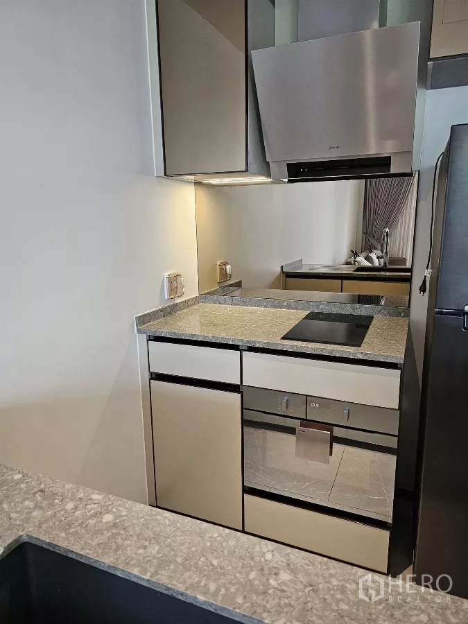 公寓 出租在Watthana, Bangkok - 紧凑现代厨房，配电磁炉、烤箱与镜面防溅板。