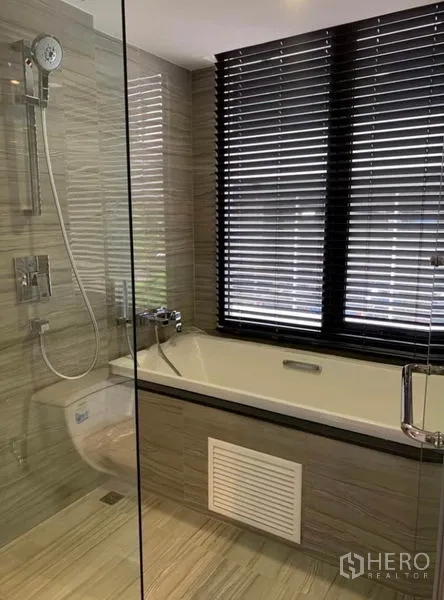 คอนโด ให้เช่าในPathum Wan, Bangkok - ห้องน้ำสมัยใหม่มีอ่างอาบน้ำข้างหน้าต่างบานเกล็ด และโซนฝักบัวแยกกระจก