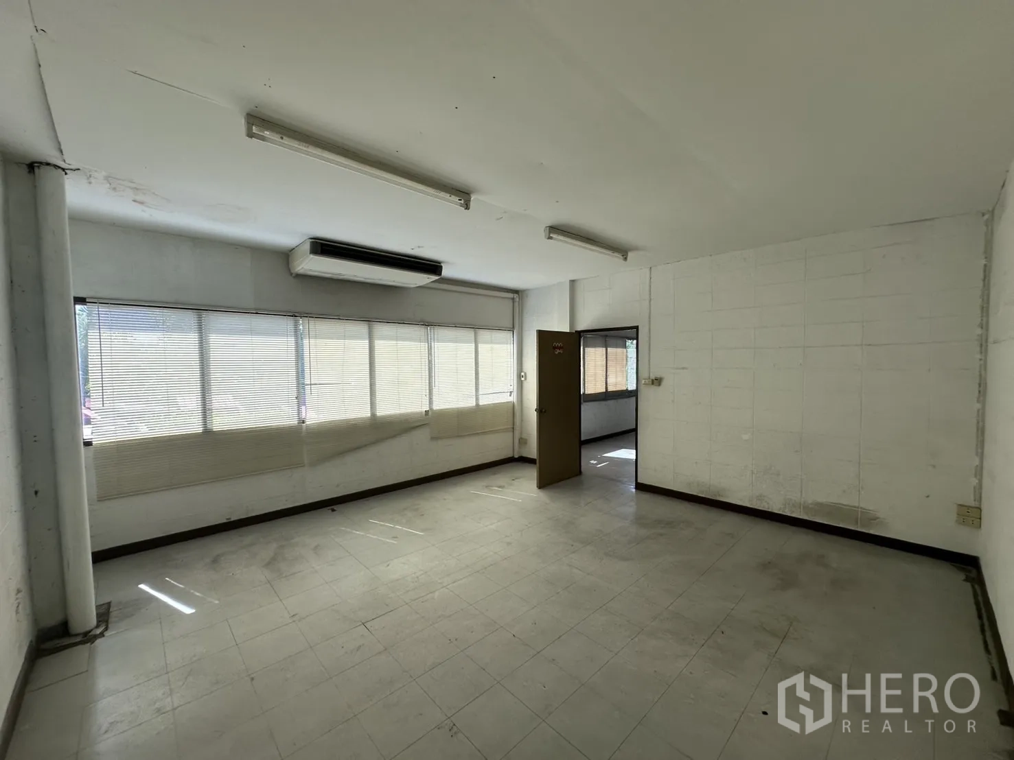 Warehouse for rent in Bang Na, Bangkok - Spacious office with long windows and built-in AC unit.