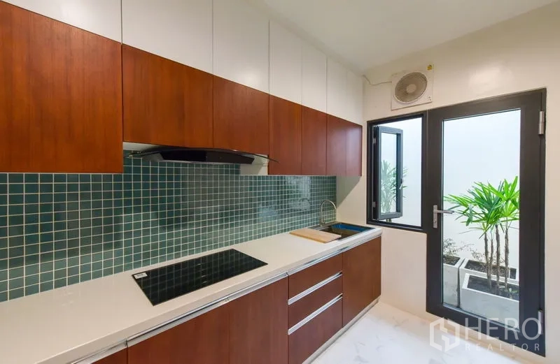 Home Office for rent or sale - Sleek kitchen with green tile backsplash, cooktop and door to a small courtyard.