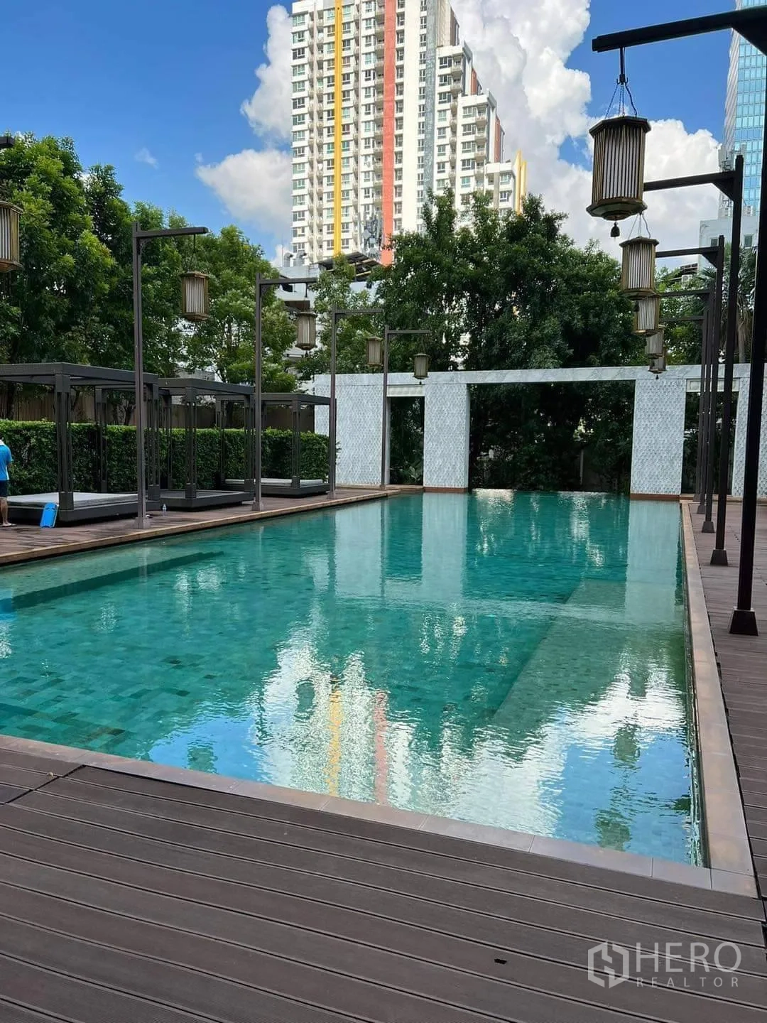 Condominium for rent or sale in Bang Rak, Bangkok - Outdoor lap pool with wooden deck and hanging lantern lights.