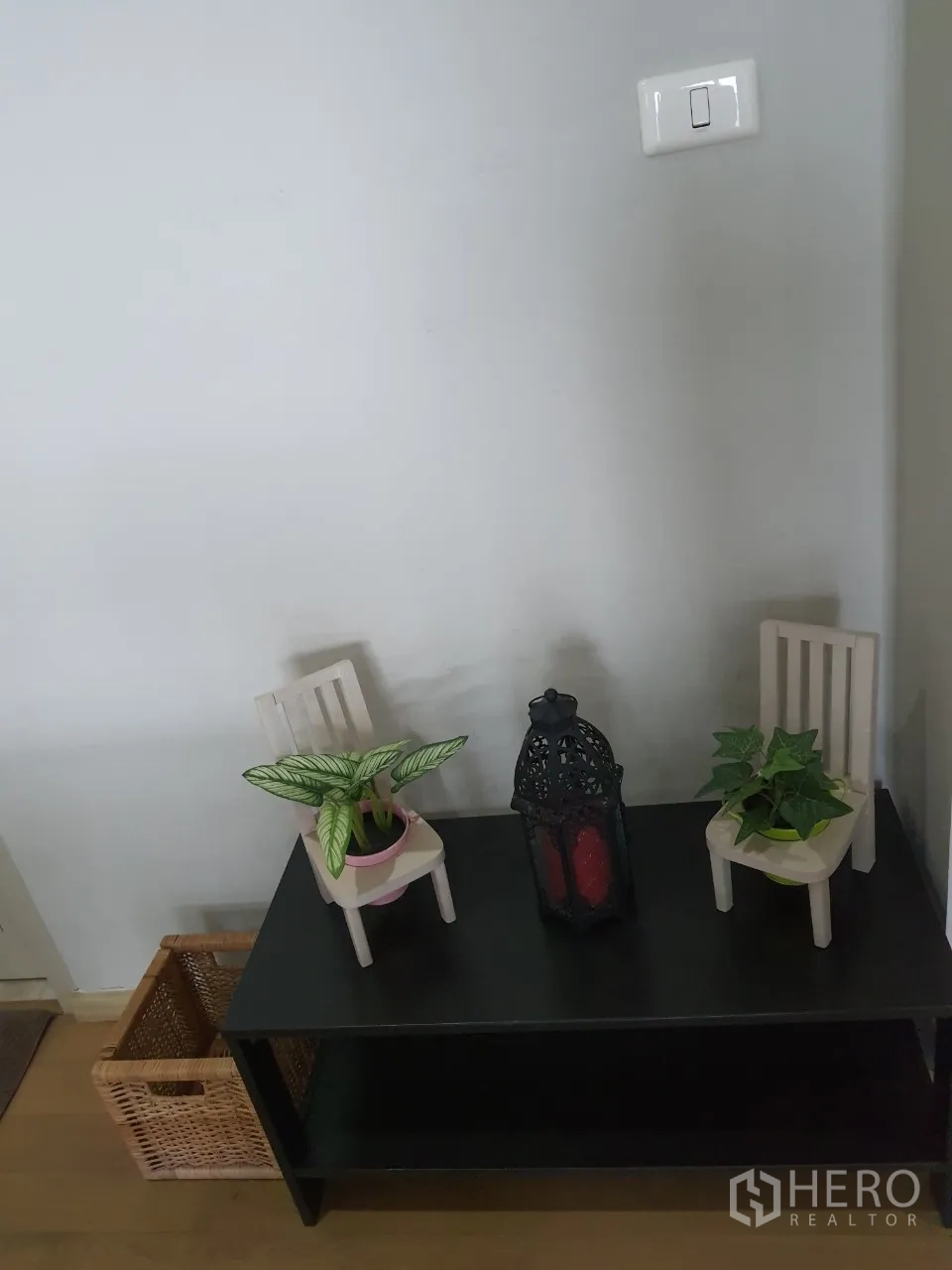 Condominium for rent or sale in Watthana, Bangkok - Entry console table with small plants, decorative lantern and woven storage basket on wood floor.
