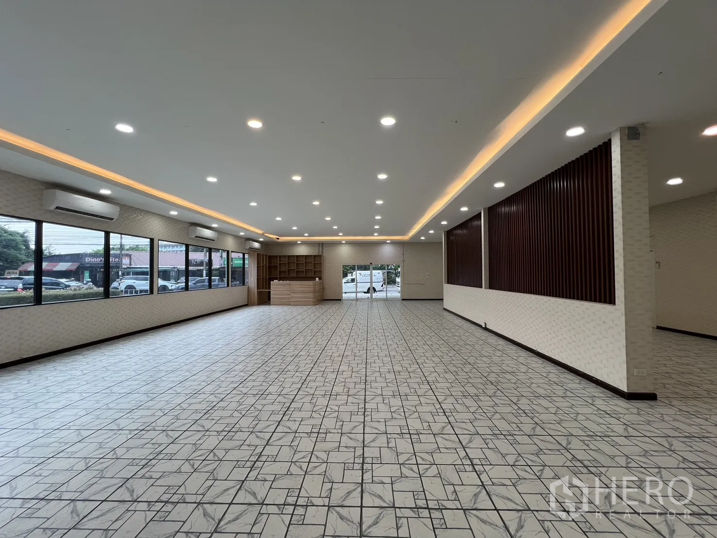 零售空间 for rent in Bueng Kum, Bangkok - 室内长窗墙面，暖色灯带照明与玻璃出入口。