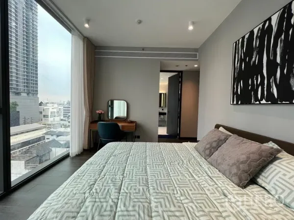Condominium for rent in Bang Rak, Bangkok - Corner bedroom with large windows, vanity and entrance to ensuite bathroom.