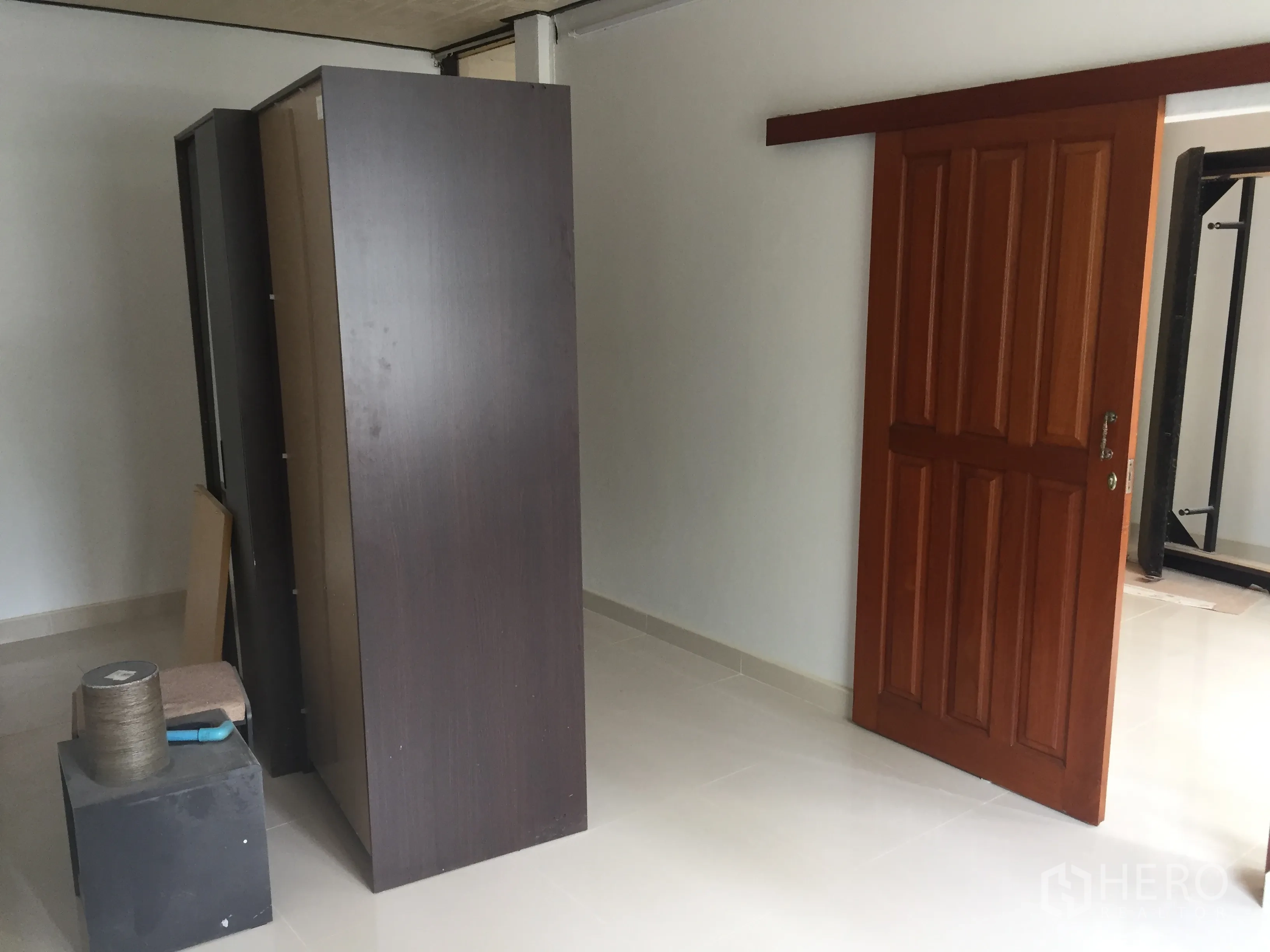 ทาวน์เฮาส์ ให้เช่าในKhlong Toei, Bangkok - ห้องพร้อมประตูไม้บานเลื่อน พื้นกระเบื้องเงา และตู้เสื้อผ้าตั้งพื้น