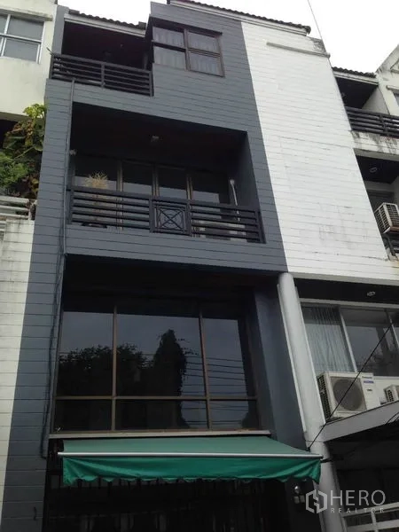 Home Office for rent or sale in Wang Thonglang, Bangkok - Four-storey home office facade with balconies, large windows and a green awning in Wang Thonglang.