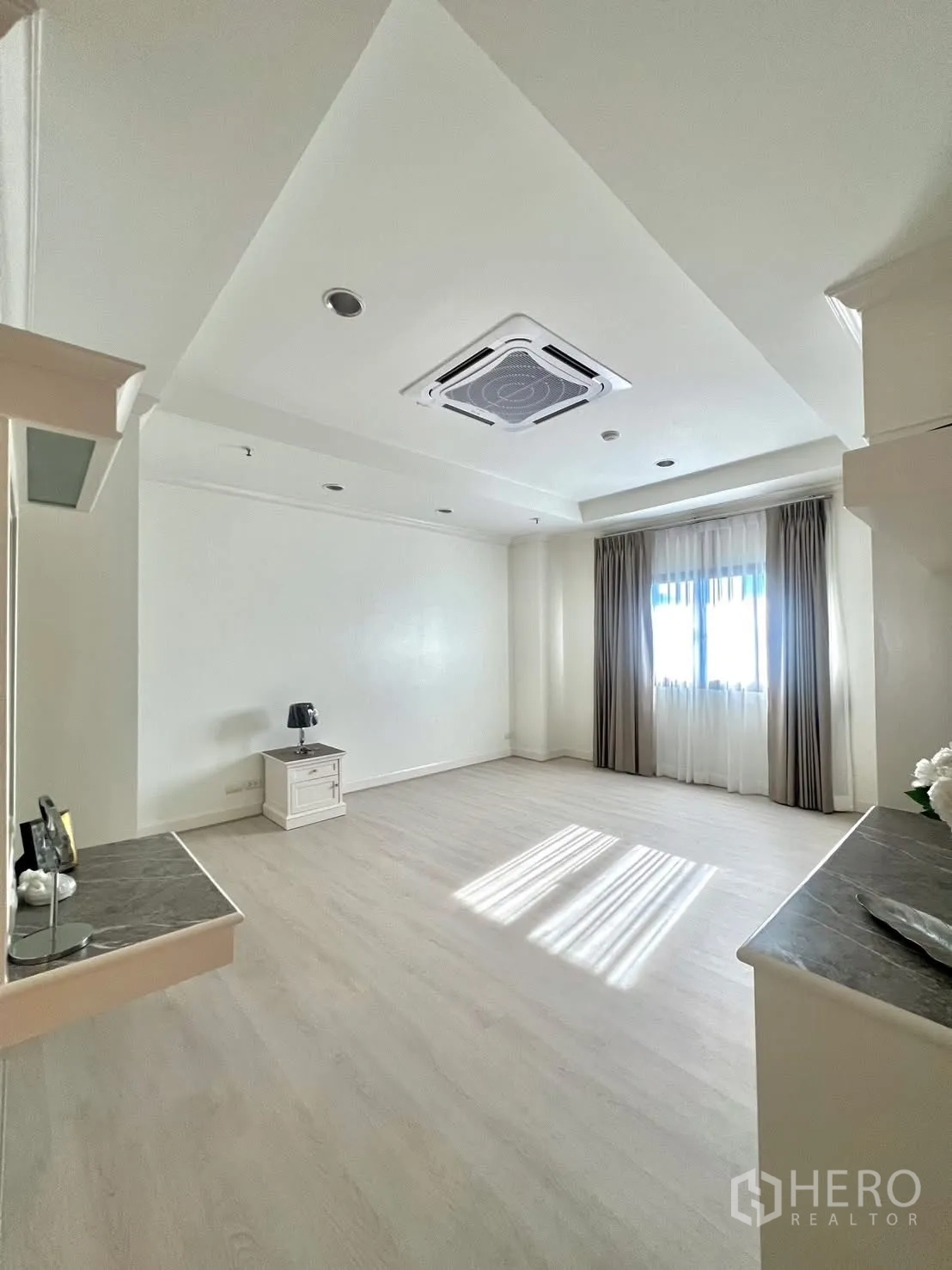 Condominium for rent in Khlong Toei, Bangkok - Bright bedroom with built-in shelves and desk beside a window.
