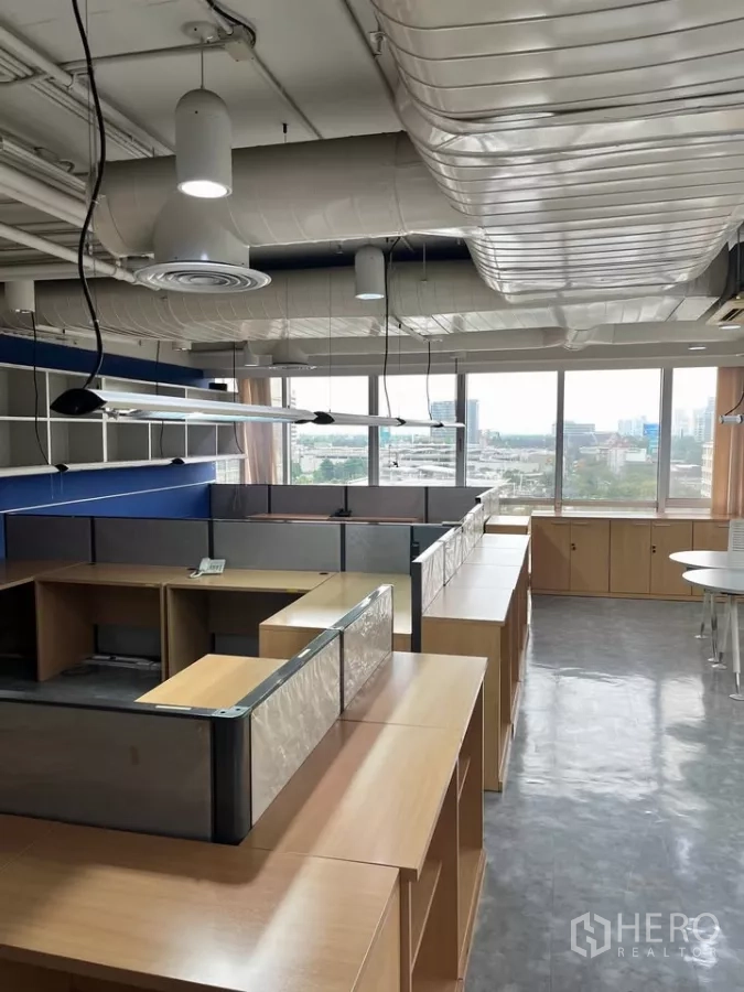 办公空间 出租在Khlong Toei, Bangkok - 面向落地窗的工位与储物柜，可观城市景色。