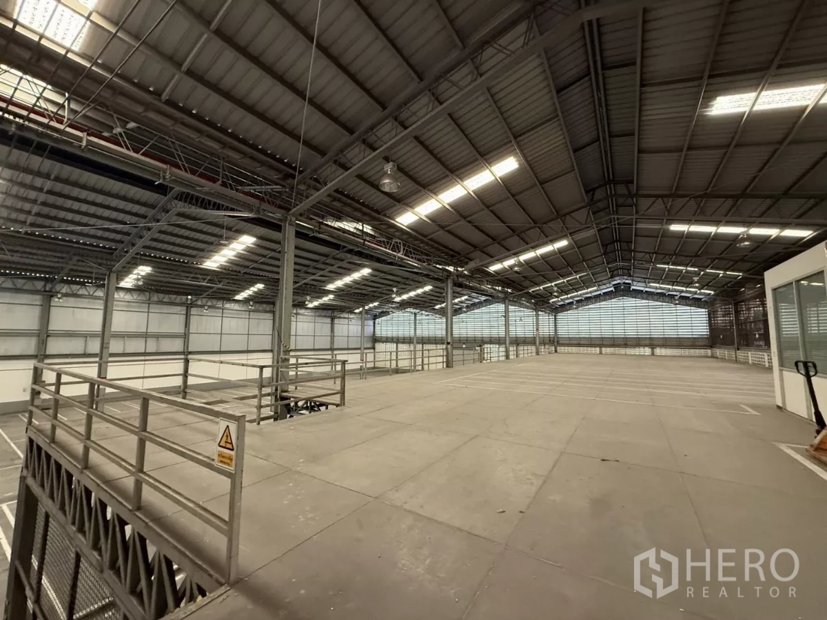 Factory for rent in Lat Krabang, Bangkok - Large mezzanine platform with safety railings overlooking the warehouse, next to a glass-partition office.