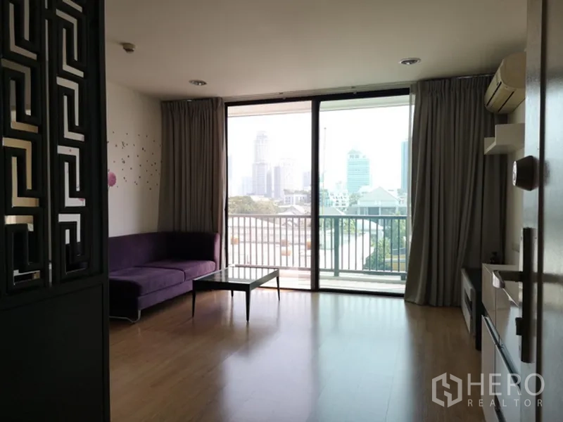 คอนโด ขายในWatthana, Bangkok - ห้องนั่งเล่นสว่าง กระจกเต็มบาน พร้อมระเบียง มองเห็นวิวเมือง โซฟาสีม่วง และพื้นไม้