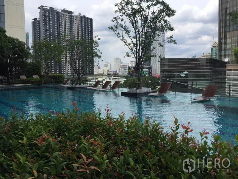 คอนโด ให้เช่าในRatchathewi, Bangkok - สระว่ายน้ำดาดฟ้าพร้อมเตียงอาบแดด ต้นไม้ และฉากหลังวิวเมือง