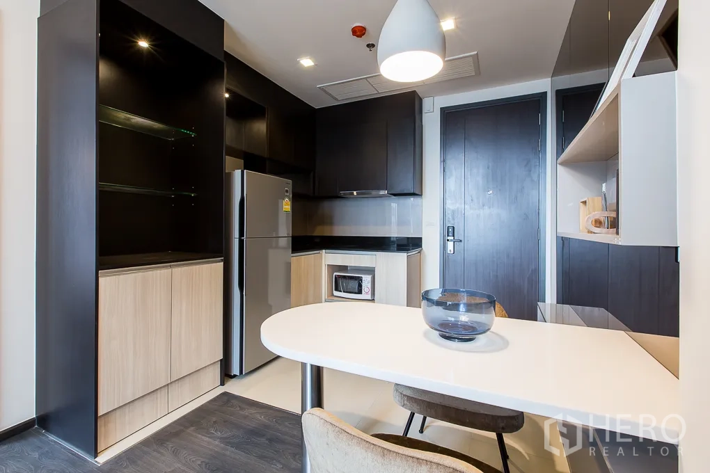 คอนโด ให้เช่าในWatthana, Bangkok - ครัวขนาดกะทัดรัด ตู้บิวท์อินทูโทน ตู้เย็น และโต๊ะทานอาหารสีขาว