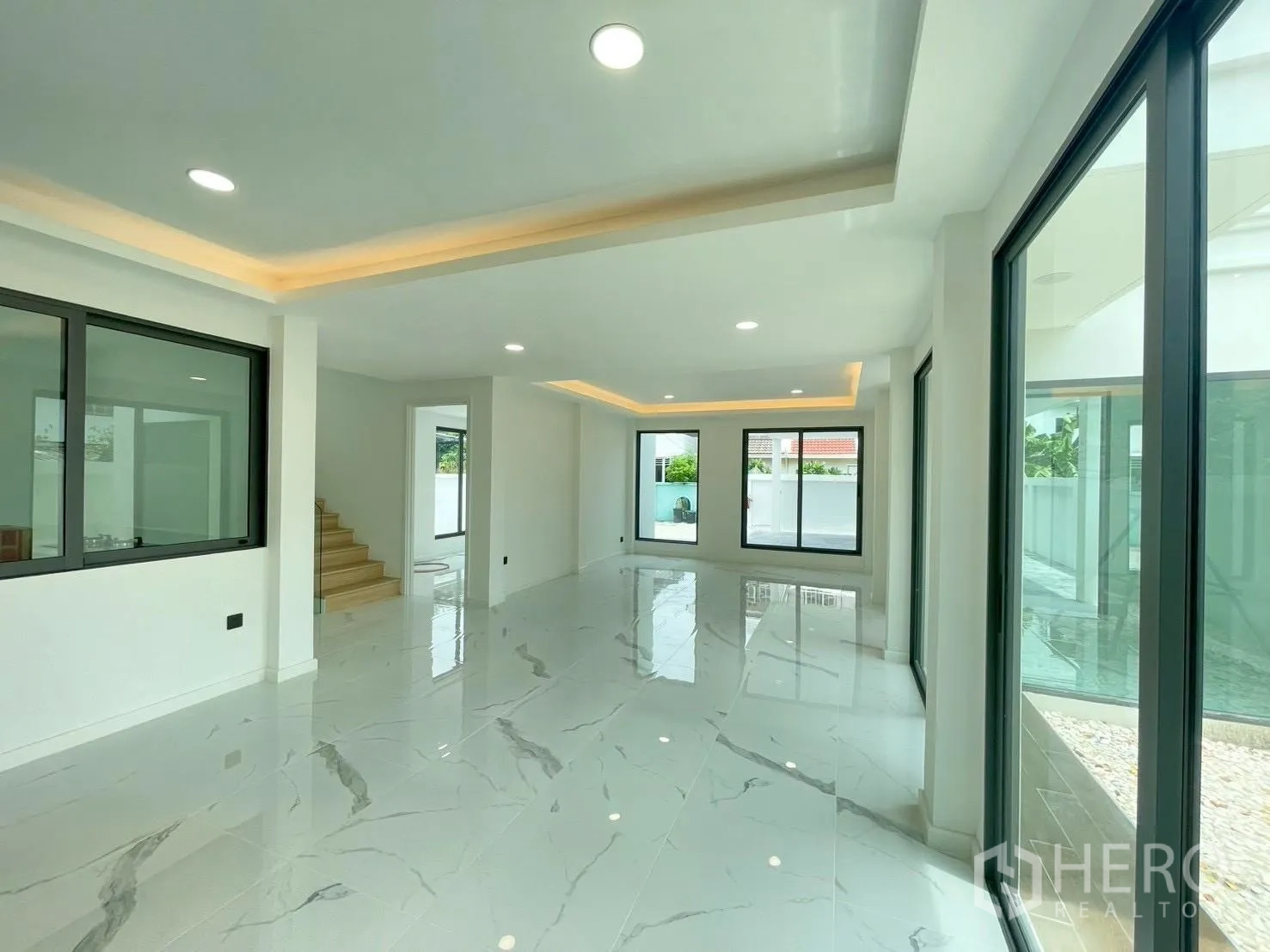 Detached House for sale in Chatuchak, Bangkok - Living-dining space with large sliding doors to the courtyard and picture windows.
