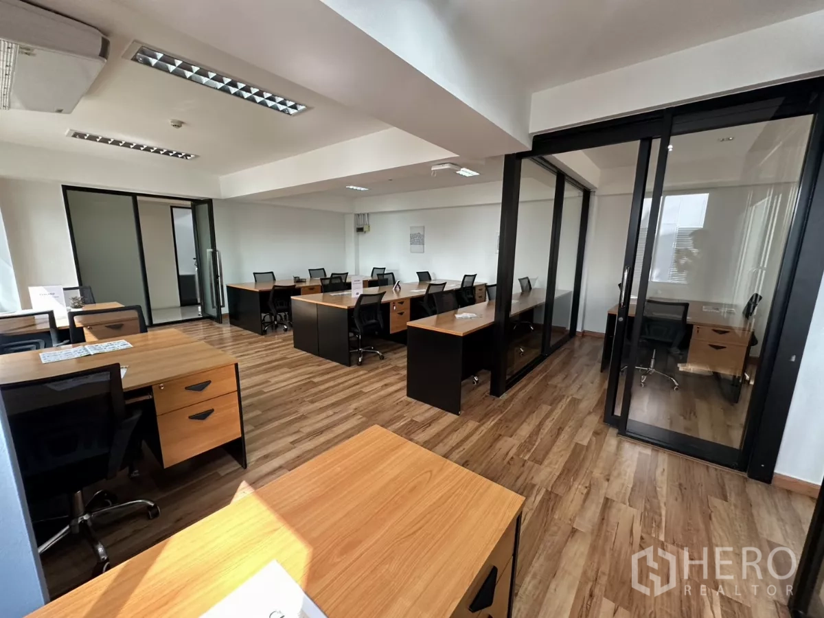 办公空间 出租在Watthana, Bangkok - 展示滑动玻璃隔断和多处工位的开放式办公空间。