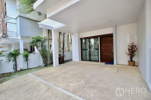 ทาวน์เฮาส์ ขายในSuan Luang, Bangkok - ที่จอดรถมีหลังคาและประตูกระจกบานเลื่อน ข้างสวนหย่อมเล็ก