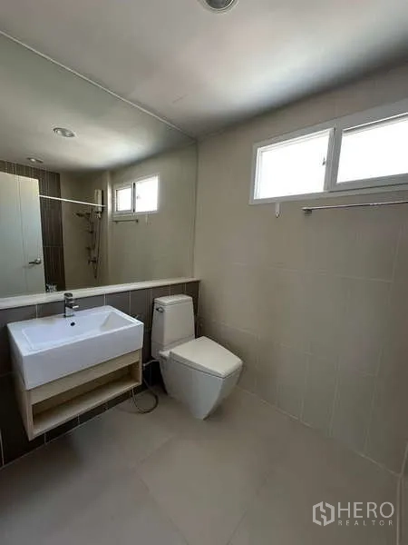 ทาวน์เฮาส์ ให้เช่าหรือขายในWang Thonglang, Bangkok - ห้องน้ำอีกห้องพร้อมอ่างล้างหน้าเหลี่ยม สุขภัณฑ์ กระจกยาว และโซนอาบน้ำมีหน้าต่าง