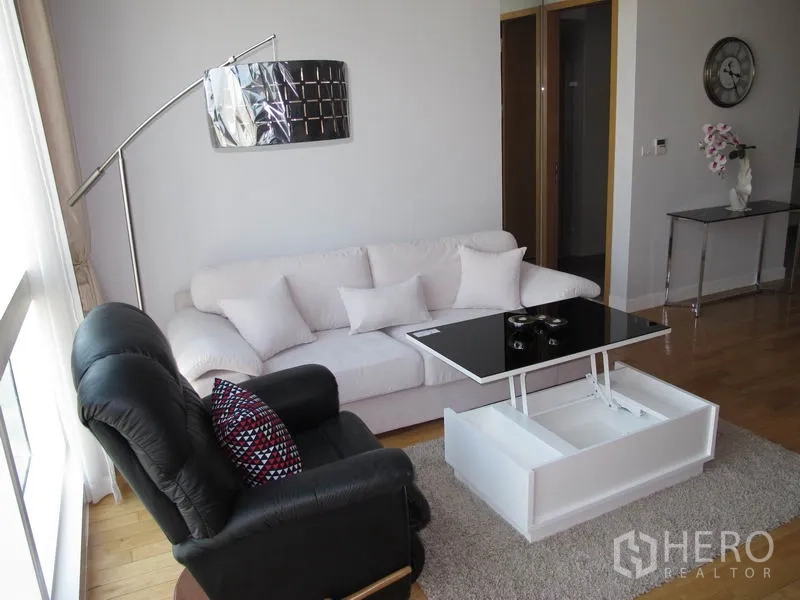 คอนโด ให้เช่าหรือขายในKhlong Toei, Bangkok - เลานจ์อบอุ่นด้วยโซฟาสีขาว เก้าอี้เอนสีดำ และโต๊ะกลางยกขึ้นได้บนพรม