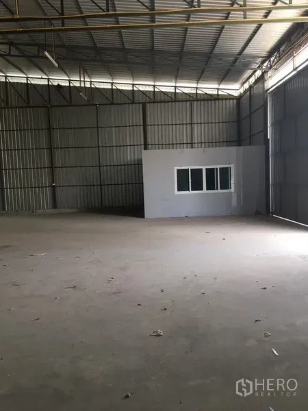 คลังสินค้า ให้เช่าในBang Kapi, Bangkok - มุมมองโกดังที่มีห้องออฟฟิศพร้อมหน้าต่าง ผนังเมทัลชีทสูง และประตูบานเลื่อนขนาดใหญ่