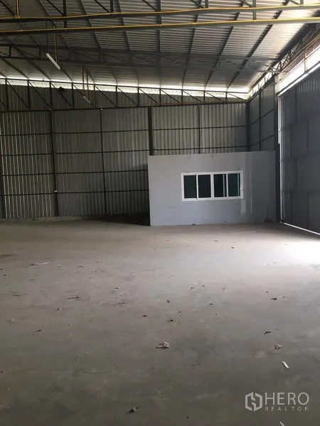 คลังสินค้า ให้เช่าในBang Kapi, Bangkok - มุมมองโกดังที่มีห้องออฟฟิศพร้อมหน้าต่าง ผนังเมทัลชีทสูง และประตูบานเลื่อนขนาดใหญ่