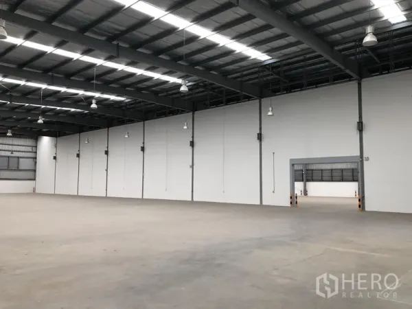 工厂 出租在Bang Sao Thong, Samut Prakan - 开阔仓储空间，隔热屋顶、白色隔墙和吊灯