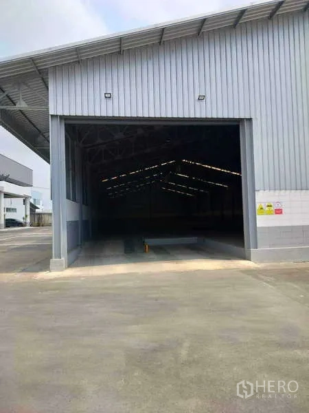 Warehouse for rent in Lat Krabang, Bangkok - Open roller shutter showing the wide-span warehouse interior