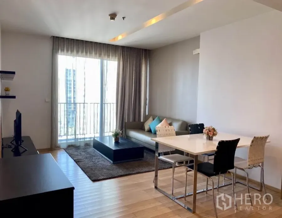 คอนโด ให้เช่าในKhlong Toei, Bangkok - ห้องนั่งเล่นและรับประทานอาหารสว่าง โปร่ง พร้อมหน้าต่างสูงจรดเพดาน ระเบียง และพื้นไม้