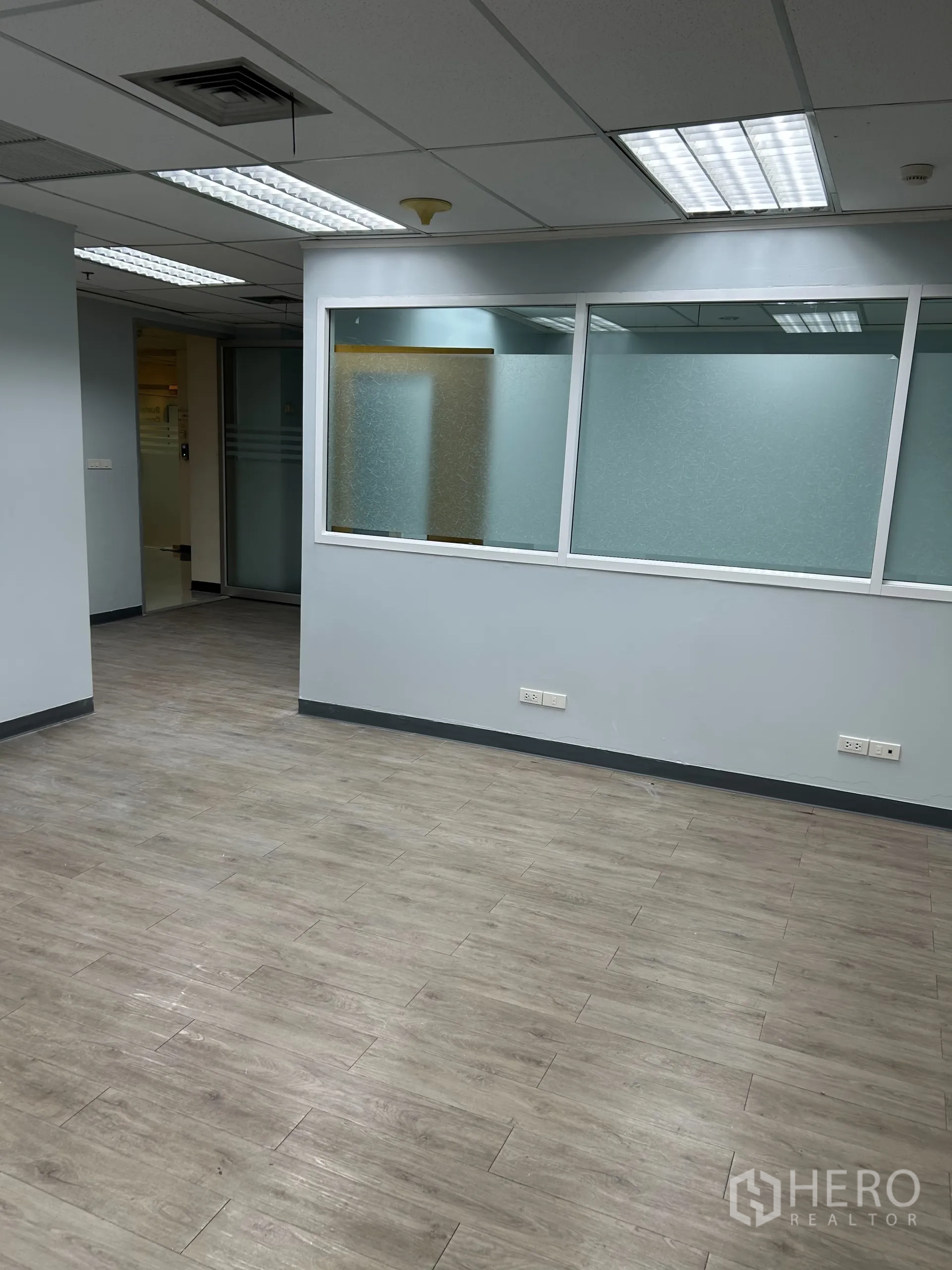 办公空间 出租在Khlong Toei, Bangkok - 走道一侧设磨砂玻璃隔断，外窗可见城市景观。