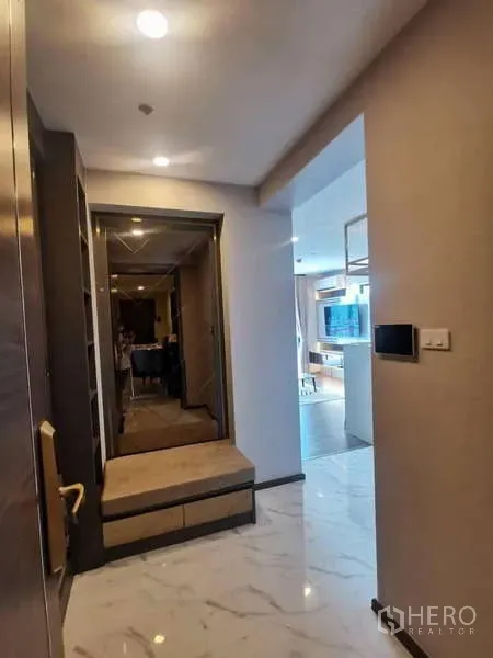 公寓 出售在Huai Khwang, Bangkok - 入口走廊铺大理石纹地面，带内置换鞋凳与镜面，通向客厅。