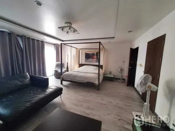 Townhouse for rent or sale in Bang Kho Laem, Bangkok - Spacious bedroom featuring a four-poster bed, sofa seating and large curtained windows.