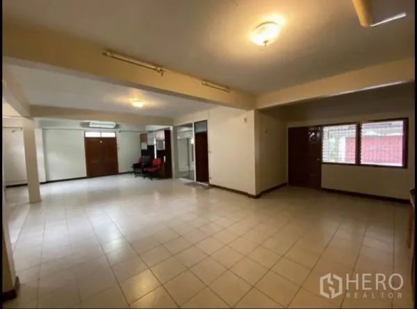 Home Office for rent in Suan Luang, Bangkok - Ground-floor area with tiled flooring, multiple entrances and a glass partition for flexible office layouts.