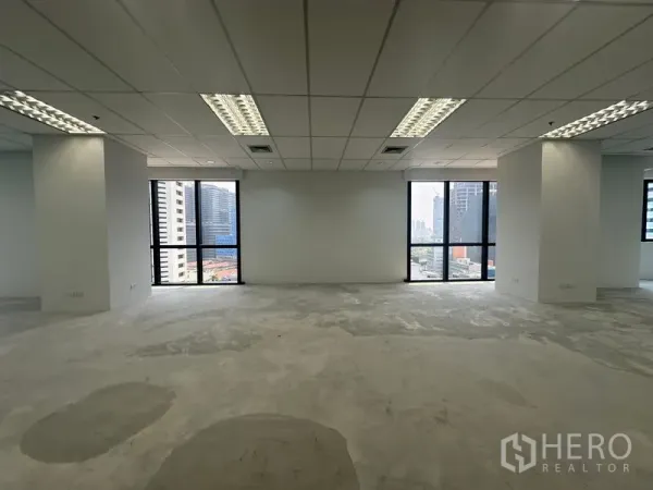 办公空间 出租在Bang Rak, Bangkok - 明亮办公室，大片窗户与城市景观，荧光灯照明，水泥找平地面。