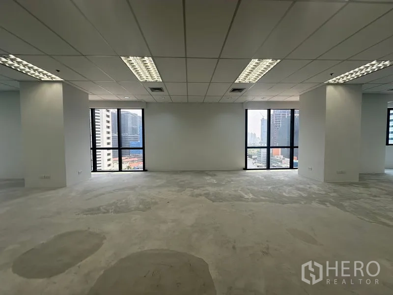 办公空间 出租在Bang Rak, Bangkok - 明亮办公室，大片窗户与城市景观，荧光灯照明，水泥找平地面。