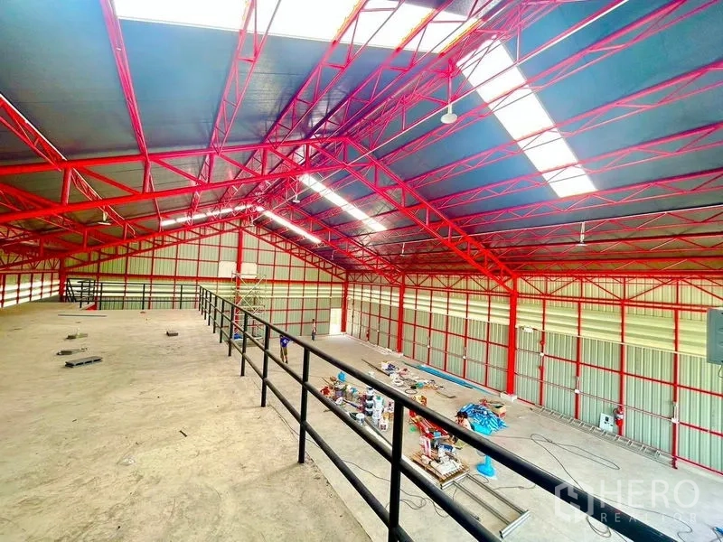 货栈 出租在Lam Luk Ka, Pathum Thani - 从夹层俯瞰高净空仓库，红色钢屋架清晰可见。